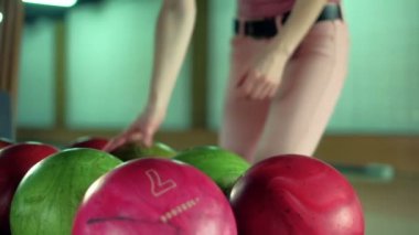 Genç kadın bir bowling club yavaş hareket topu atıyor