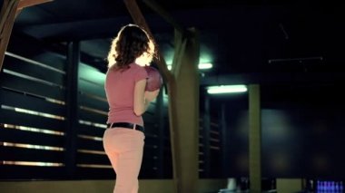Genç kadın bir bowling club yavaş hareket topu atıyor