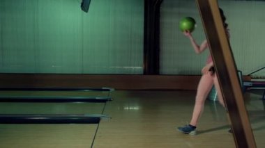 Genç kadın bir bowling club yavaş hareket topu atıyor