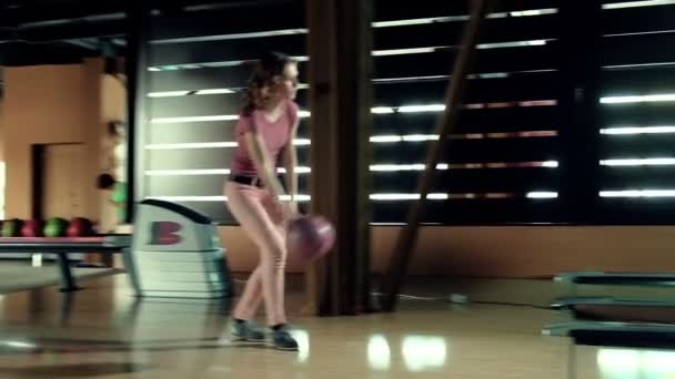 年轻女子在保龄球俱乐部慢动作扔球 — 图库视频影像
