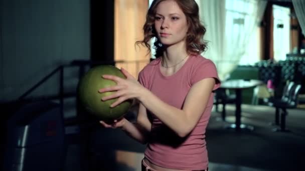 Молодая женщина бросает мяч в боулинг-клуб — стоковое видео