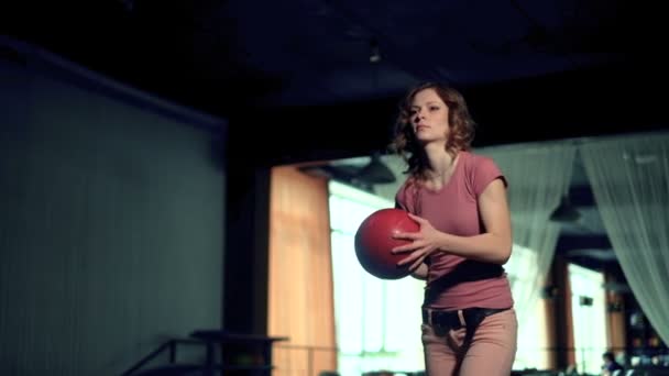 Νεαρή γυναίκα ρίχνει μπάλα σε μια λέσχη μπόουλινγκ αργή κίνηση — Αρχείο Βίντεο