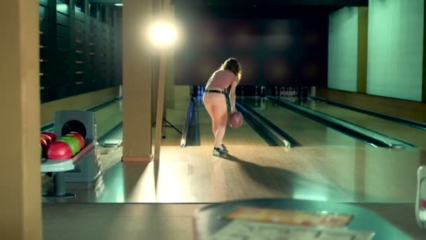 Junge Frau wirft Ball in Zeitlupe in Kegelclub — Stockvideo