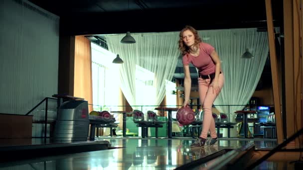 Giovane donna sta lanciando palla in un club di bowling rallentatore — Video Stock