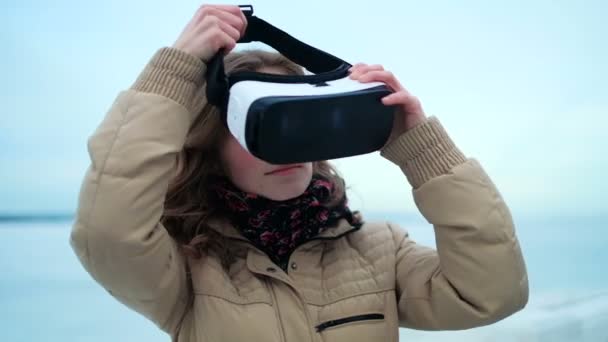 Женщина использует очки виртуальной реальности на улице — стоковое видео