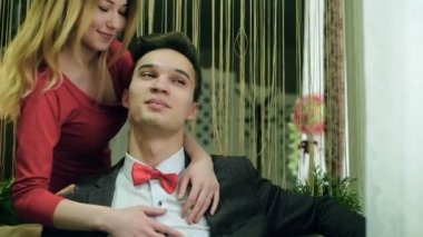 Kollarında kanepede oturan ve her diğer sevecen bir çift. Ağır çekim mutlu