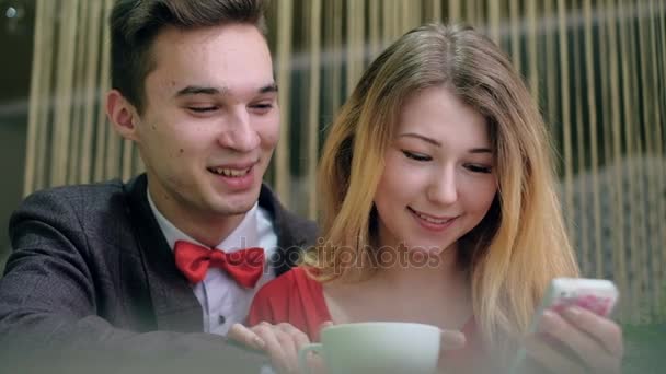 携帯電話のようなカフェに座っていると selfie 写真を撮る幸せなカップル — ストック動画