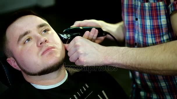 Barber coupe les cheveux dans le salon de coiffure. Mouvement lent . — Video