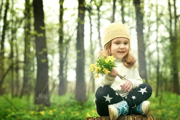 Meisje close-up ruiken een gele bloem op een groene achtergrond gelukkig — Stockfoto