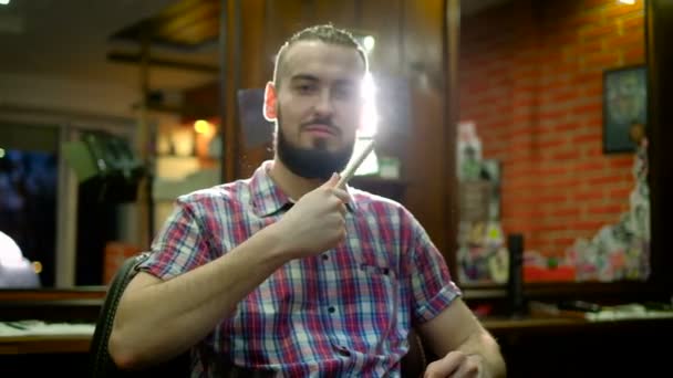Yeni saç kesimi zamanı. Yakışıklı genç adam onun yansıması aynaya bakarak ve Berber Dükkanı, sandalyede oturan ise en iyi saç içinde el tutmak sakallı — Stok video