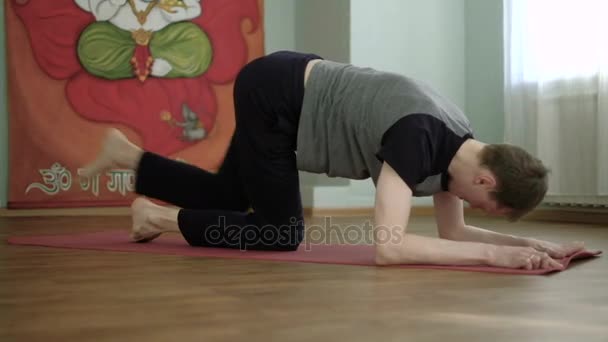 A man yoga makes a healthy stretching in the studio — Stock Video