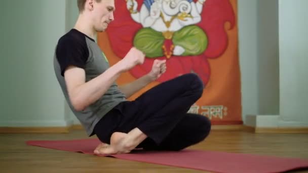 Un homme yoga fait un étirement sain dans le studio — Video