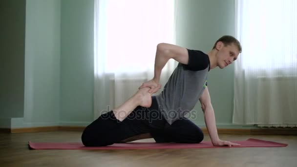 Un homme yoga fait un étirement sain dans le studio — Video