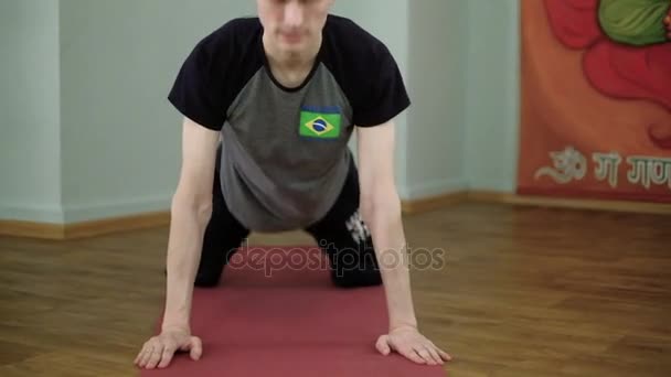 Un hombre yoga hace un estiramiento saludable en el estudio — Vídeo de stock