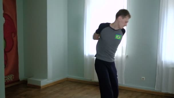 Un hombre yoga hace un estiramiento saludable en el estudio — Vídeo de stock