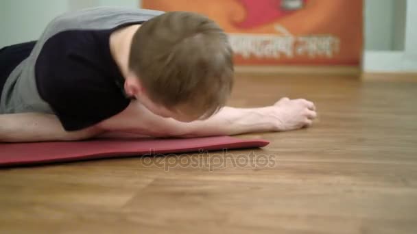A man yoga makes a healthy stretching in the studio — Stock Video