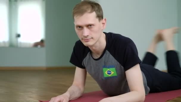 Un hombre yoga hace un estiramiento saludable en el estudio — Vídeo de stock