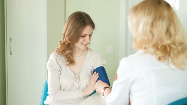 Medico che misura la pressione sanguigna della donna in ospedale 4k — Video Stock