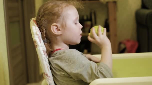 Niña comiendo una manzana verde y sonriendo 4k — Vídeos de Stock