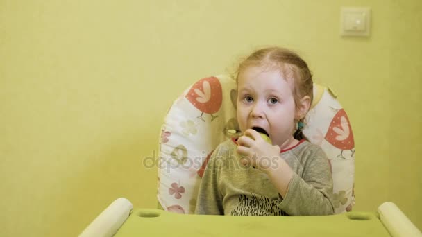 Μικρό κορίτσι τρώει ένα πράσινο μήλο και χαμογελαστός 4k — Αρχείο Βίντεο