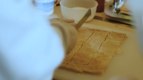 Шеф-повар разрезает слоеное тесто на полоски. 4k — стоковое видео