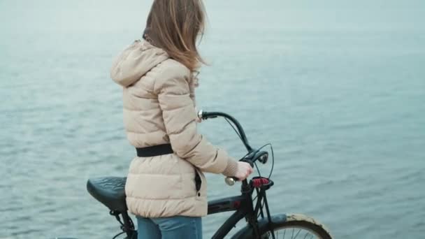 Menina na bicicleta vintage desfrutando em frente ao mar 4k — Vídeo de Stock