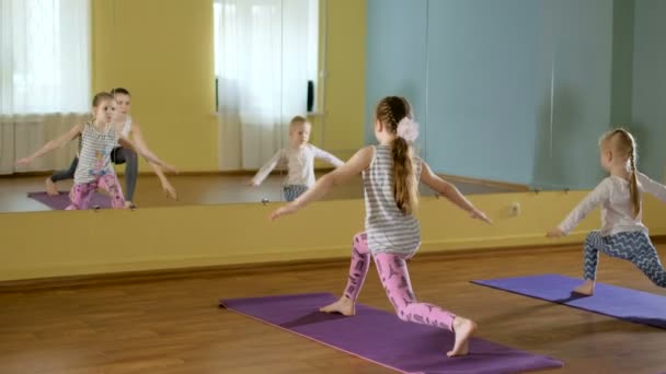 Мати і дочки роблять йогу разом у фітнес-студії 4k — стокове відео