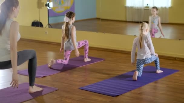 Mother and daughtersr doing yoga together in a fitness studio 4k — Stock Video