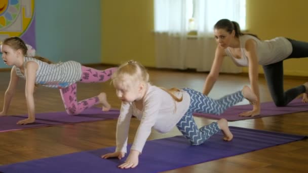 Mère et filles faisant du yoga ensemble dans un studio de fitness 4k — Video