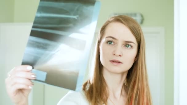 Médecin professionnel féminin lisant un film radiographique du cerveau et au téléphone 4k — Video