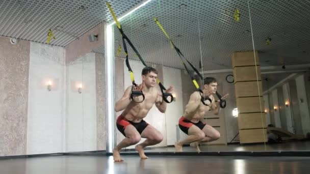 Мужчина занимается трэкс-упражнениями в студии 4k — стоковое видео