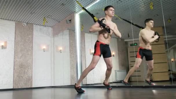 L'homme est engagé dans des exercices trx dans le studio 4k — Video