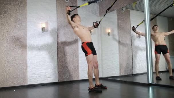 L'homme est engagé dans des exercices trx dans le studio 4k — Video