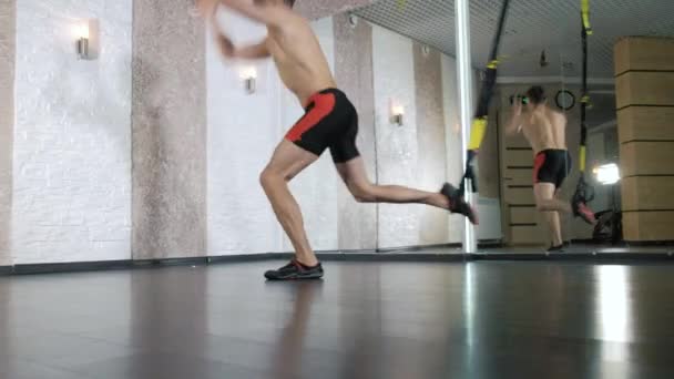 L'homme est engagé dans des exercices trx dans le studio 4k — Video