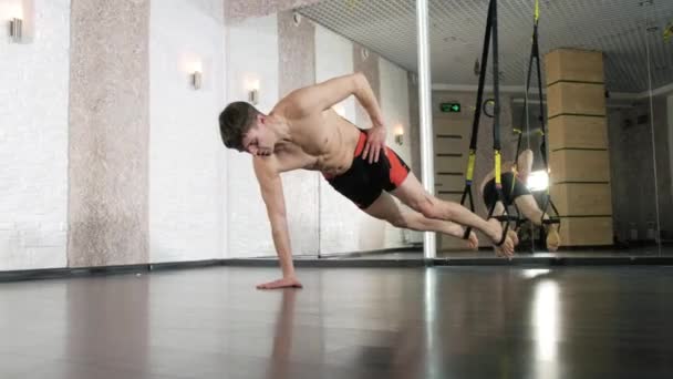 Мужчина занимается трэкс-упражнениями в студии 4k — стоковое видео