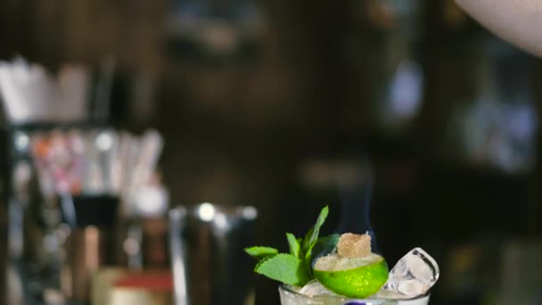 De barman bereidt een cocktail en zet het op brand 4k — Stockvideo
