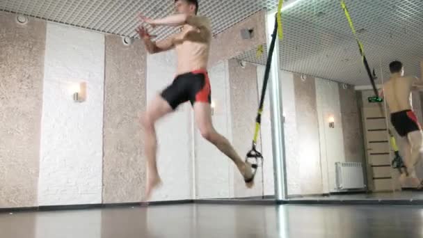 Man is engaged in trx exercises in the studio 4k — Stock Video