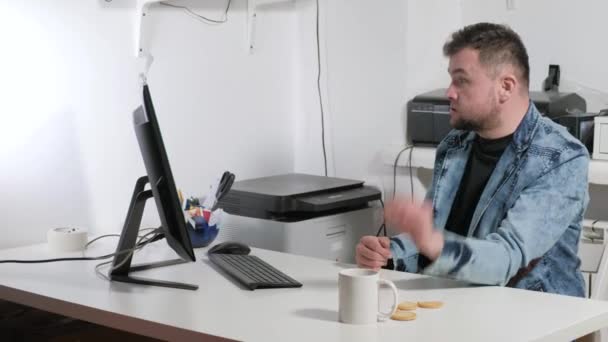 O empresário conduz emocionalmente um diálogo. No escritório, sentado no computador 4k — Vídeo de Stock