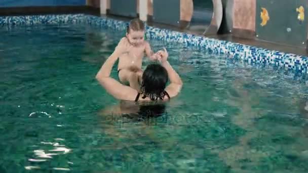 Feliz madre enseñando a su hijo en la piscina 4k — Vídeo de stock