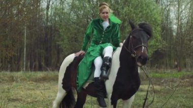 Yeşil elbiseli bir kadın 4 k ata biniyor