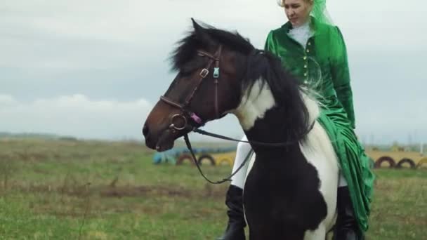 Eine Frau im grünen Anzug reitet auf einem Pferd 4k — Stockvideo