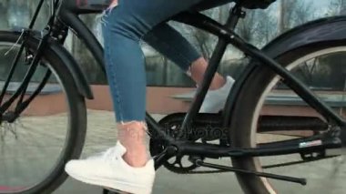 Güzel kadın uzun boylu 4 k bina yakınındaki bir bisiklet ile gidiyor