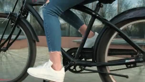 Женщина катается на велосипеде возле высотного дома 4к — стоковое видео