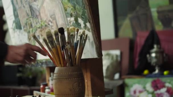 Un artista de edad avanzada escribe una foto en su estudio 4k — Vídeos de Stock