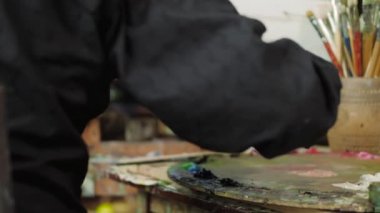 Yaşlı bir sanatçı bir resim onun stüdyosunda 4 k yazıyor.
