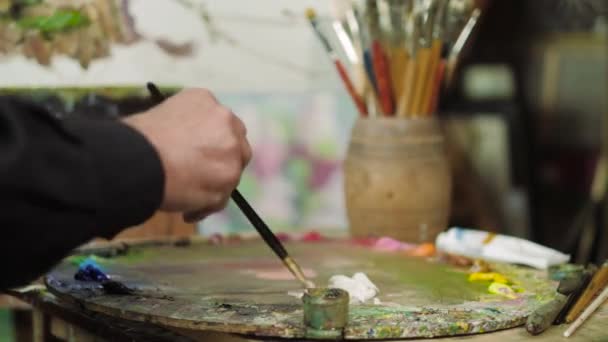 Un artista de edad avanzada escribe una foto en su estudio 4k — Vídeo de stock