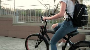 Güzel kadın uzun boylu 4 k bina yakınındaki bir bisiklet ile gidiyor