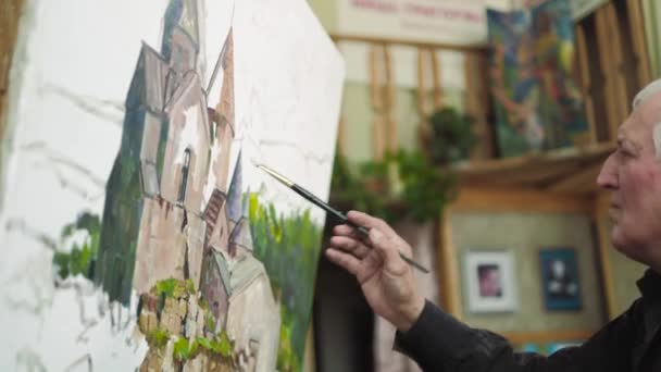Podeszłym wieku artysta zapisuje obraz w jego studio 4k — Wideo stockowe