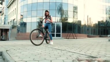 Güzel kadın uzun boylu 4 k bina yakınındaki bir bisiklet ile gidiyor