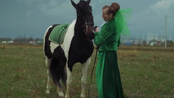 Una donna in abito verde sta cavalcando un cavallo 4k — Video Stock